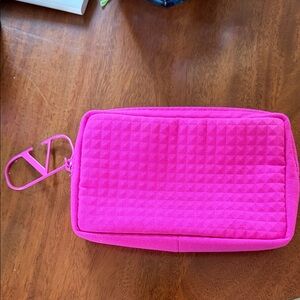 :
This hot pink pouch is a Valentino Beauty cosmetic bag,